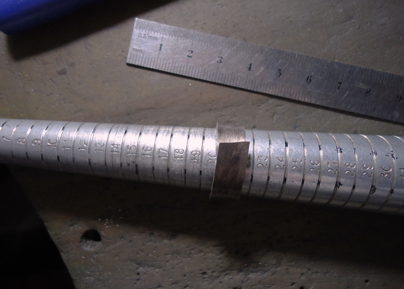 Ring placed on a sizing stick next to a millimetre ruler.